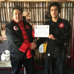 Martial Arts Mastery GM Mauricio Novoa certifying his student to to black belt